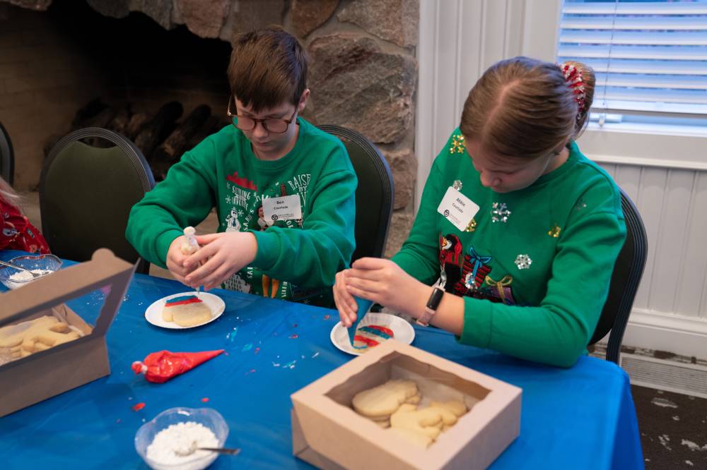 Two kids decorating cookies.